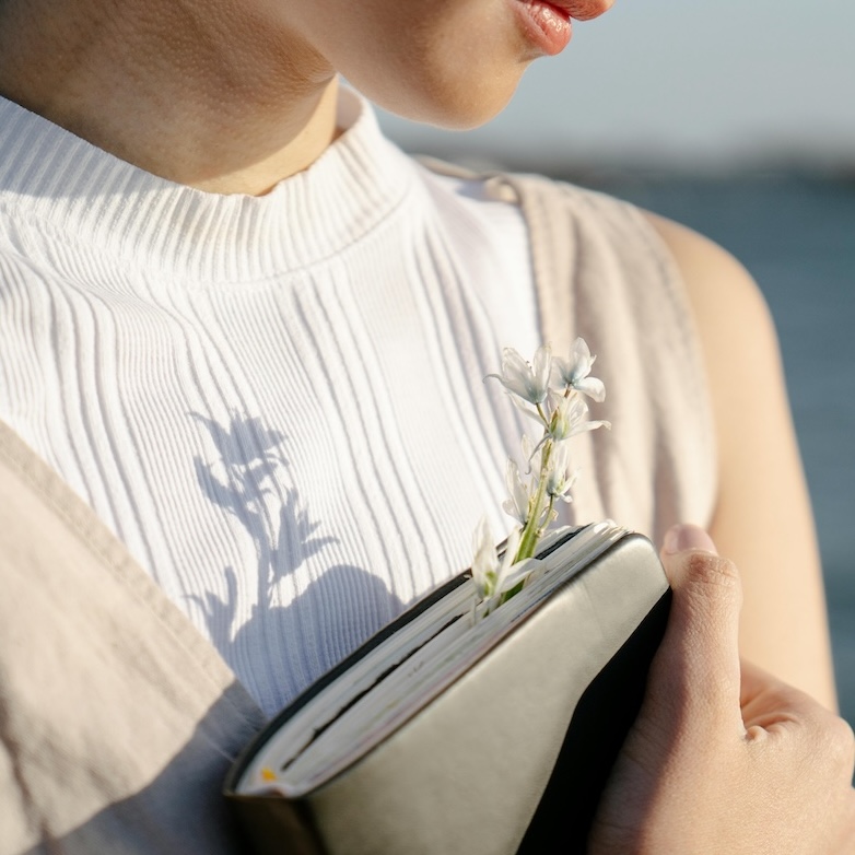 Giving Thanks through Hardship - woman clasping Bible